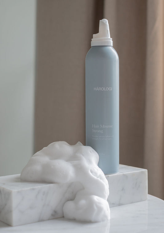 Hårologi hair mousse for volum og fyldigere hår stylingprodukt, lyseblå skumflaske på marmorkloss