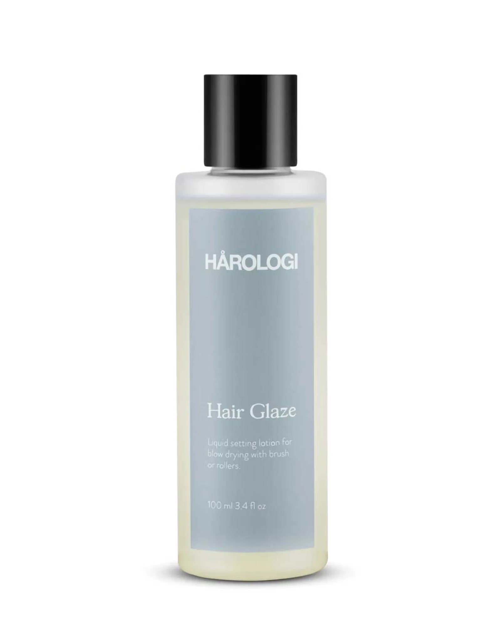 Gjennomsiktig plastflaske med blå etikett og sort skrukork. HÅROLOGI Hair Glaze – Stylingvæske for føning og glans